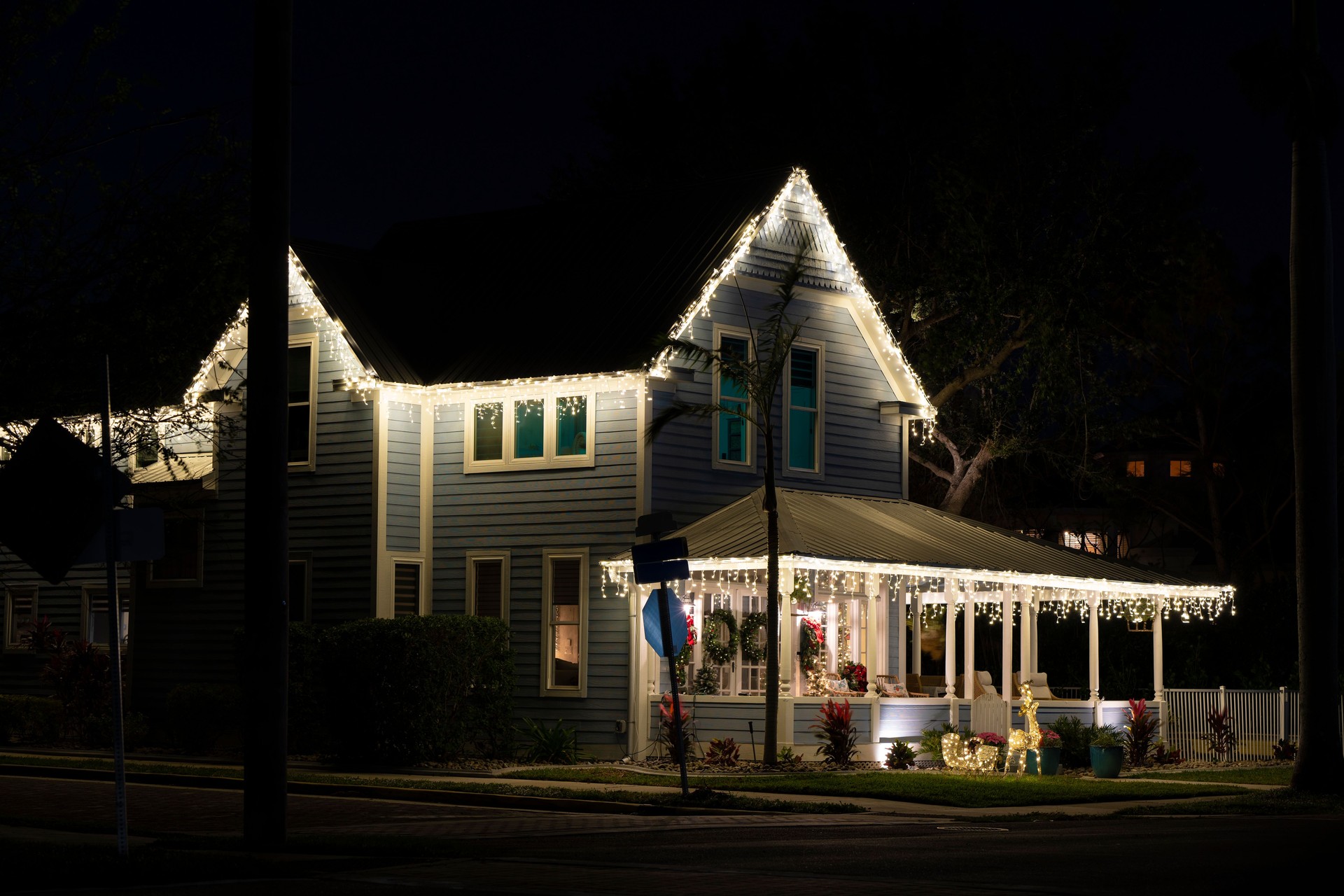 Brightly illuminated christmas decorations on front yard porch of florida family home. Outside decor for winter holidays