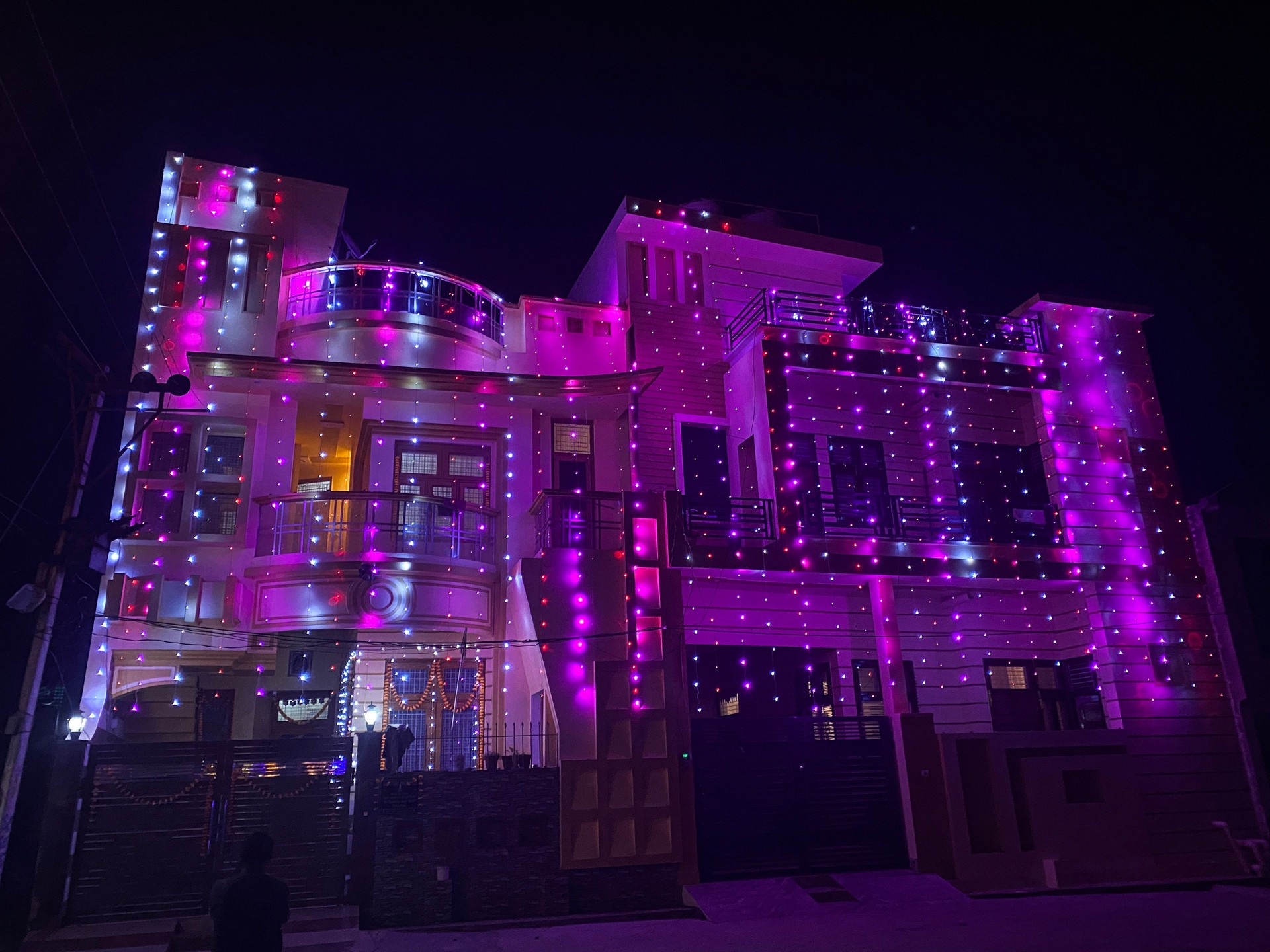 Image of house decorated with white and pink fairy lights for Indian traditional festival of lights